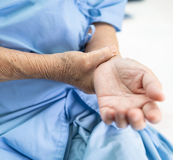 An eldery person holding his/her wrist