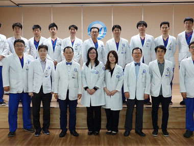 A group of doctors smiling and posing together for a photo.